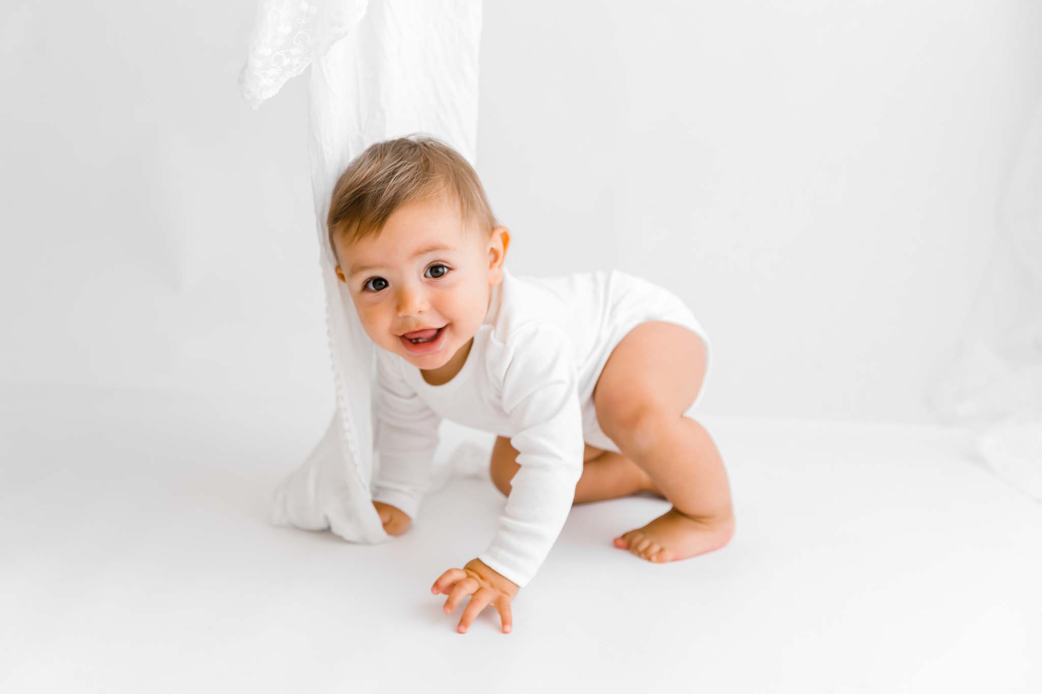 Baby ist im Vierfüßlerstand und Krabbelt beim Fotoshooting