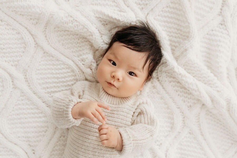 Grübelndes Baby mit dunklen Haaren beim Baby Fotoshooting München