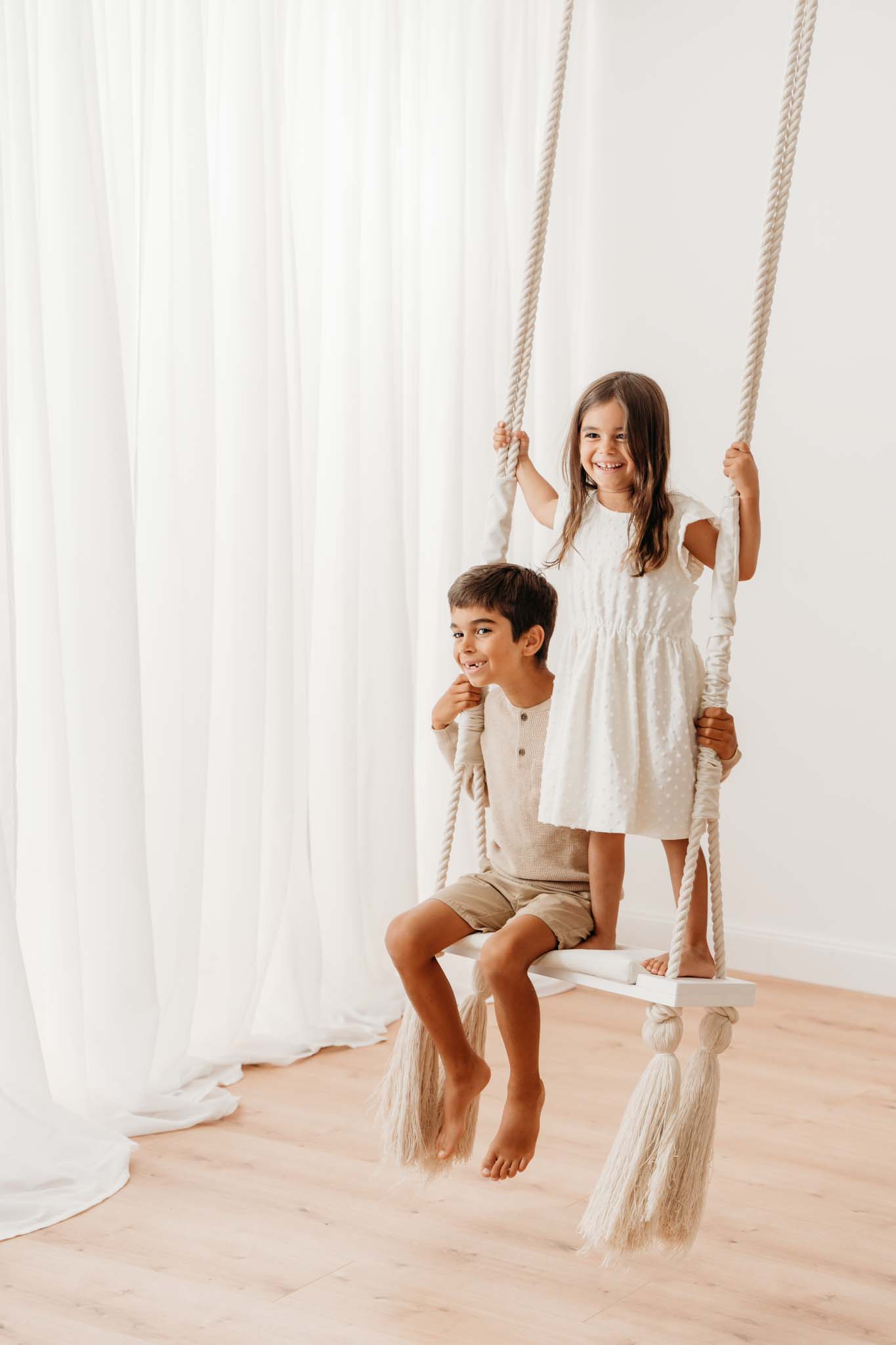 Kinder schaukeln im Fotostudio beim Familien- Fotoshooting Kinder auf Schaukel beim Familienshooting