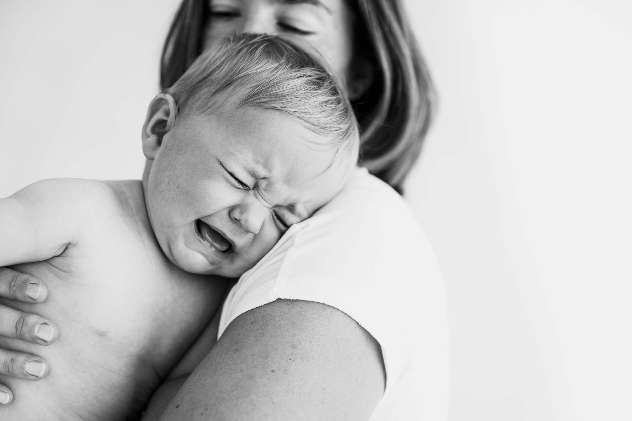 Weinendes Baby wird von Mama getröstet